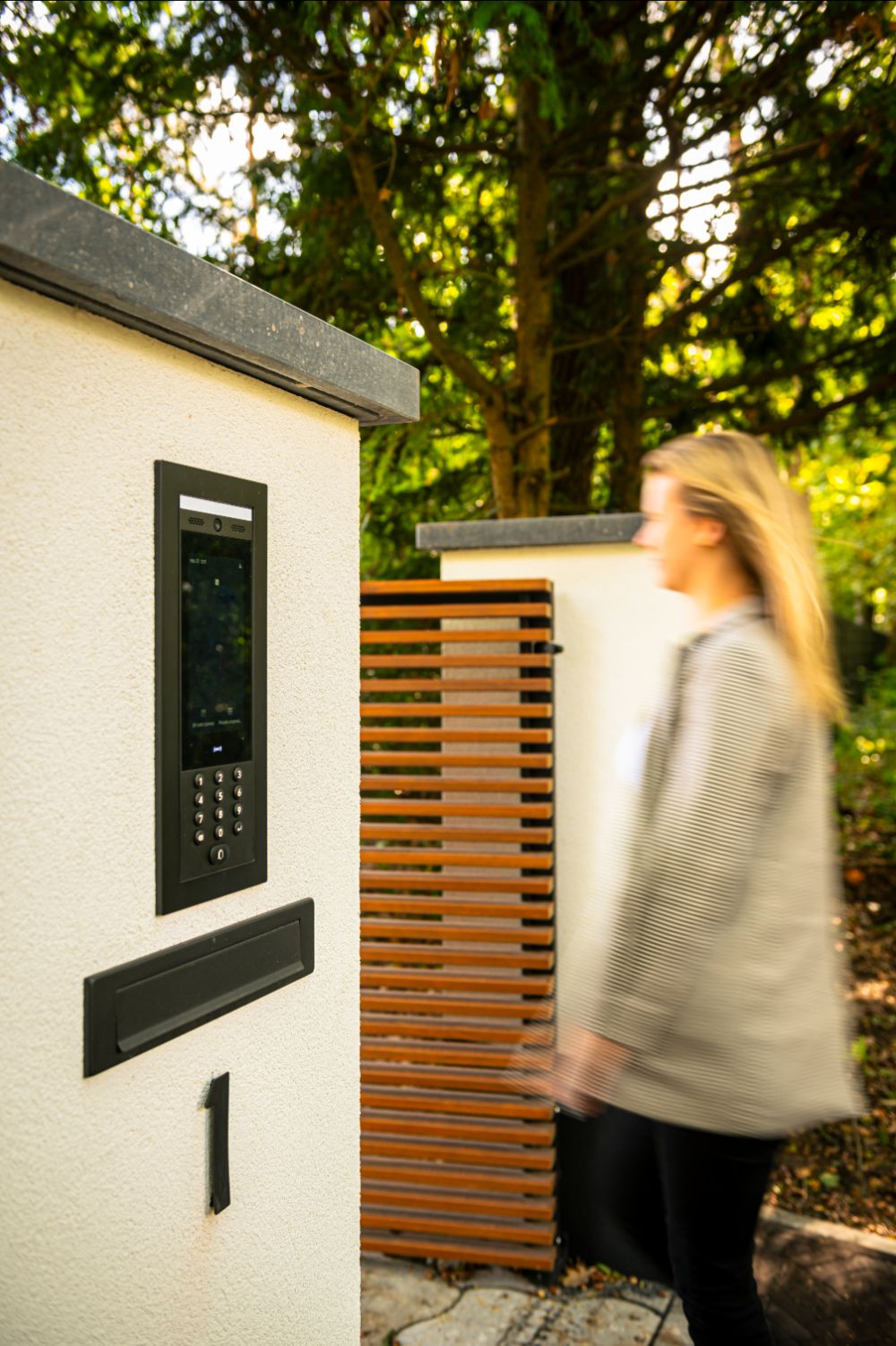 persoon loopt door houtenpoort