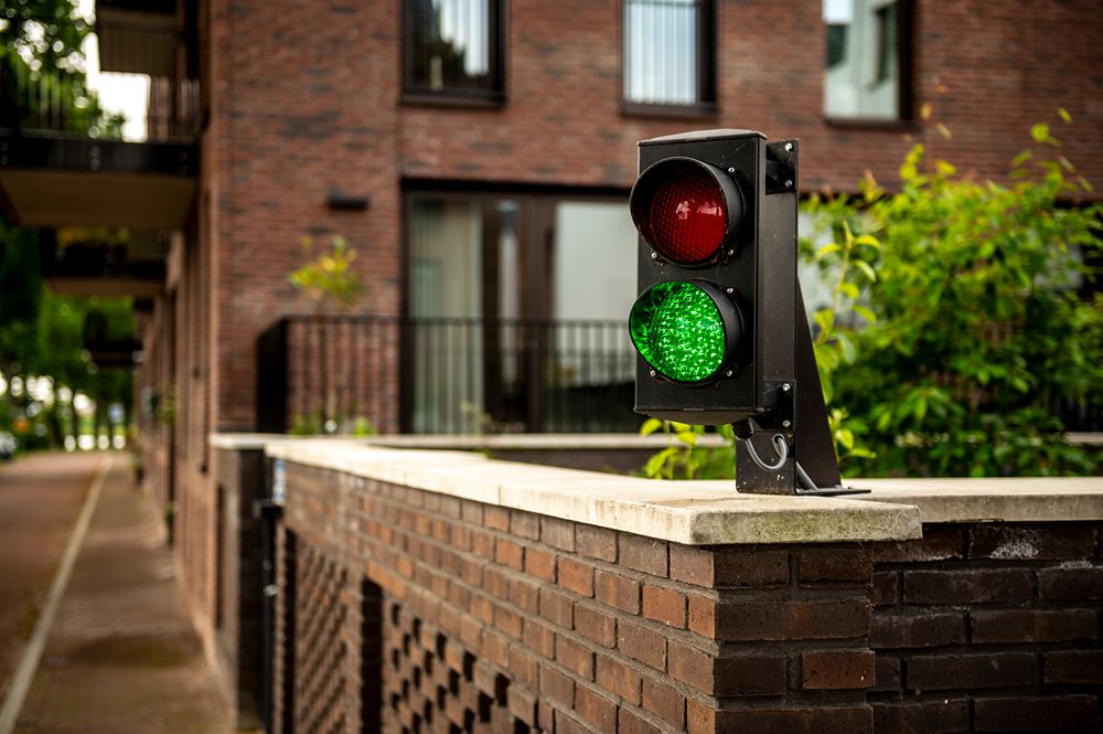 stoplicht op groen boven op gemetselde muur