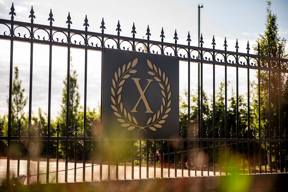 voorkant poort achter de bladeren met logo