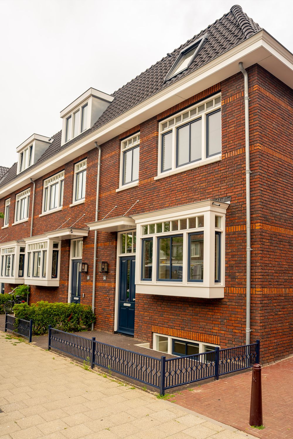 voorkant huis met blauwe hek laag