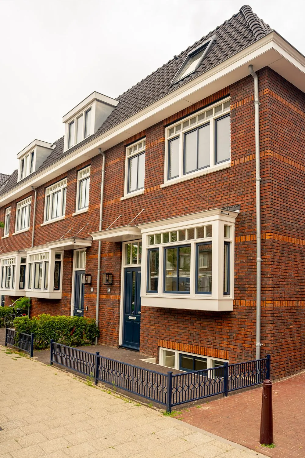 voorkant huis met blauwe hek laag